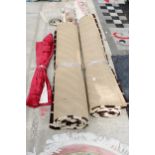TWO LARGE BROWN PATTERNED RUGS AND A ROLL OF MATERIAL