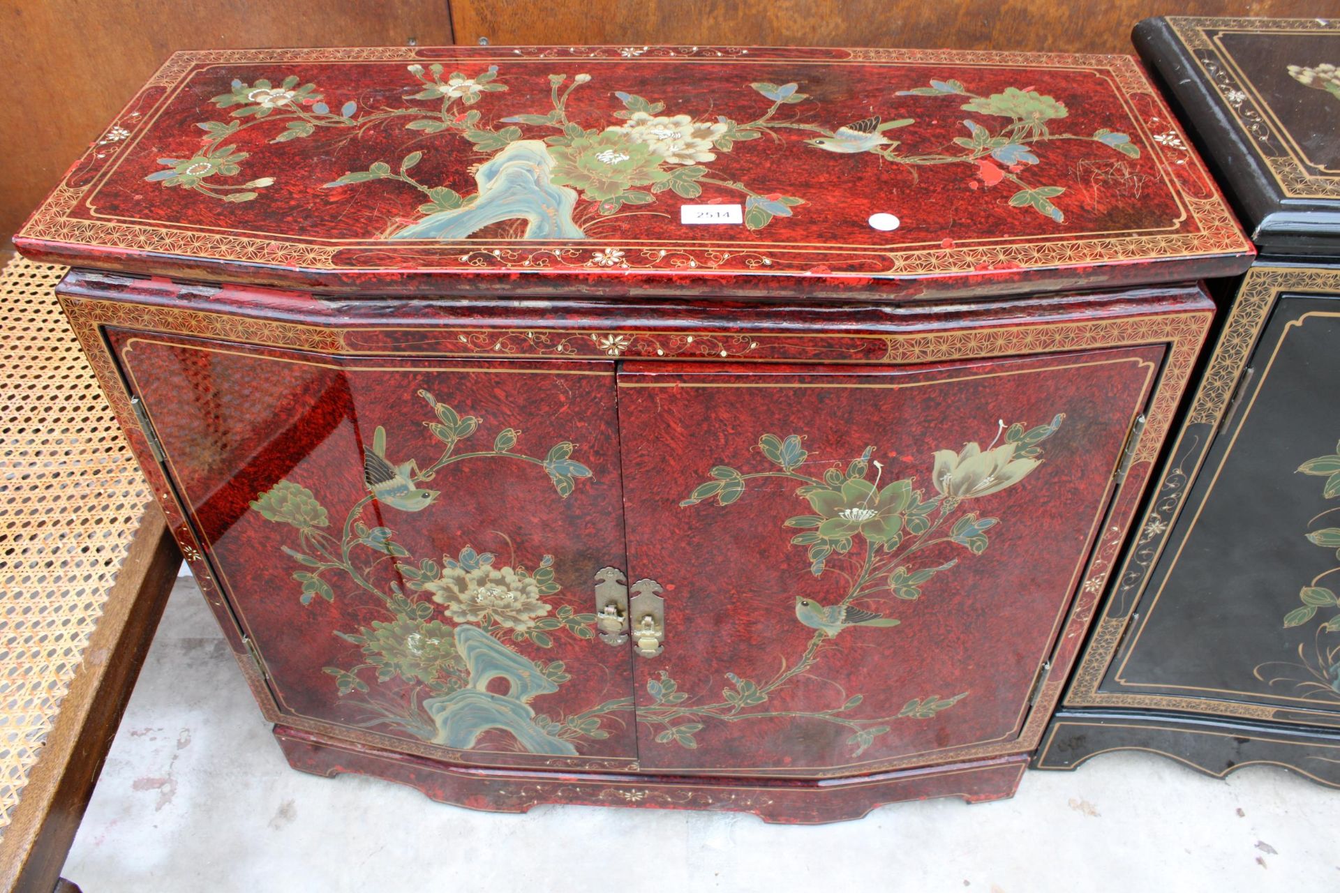 A 19TH CENTURY STYLE RED GROUND TWO-DOOR SIDE CABINET WITH CHINOISERIE DECORATION, 32" WIDE