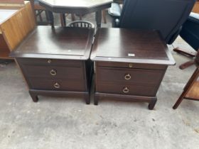A PAIR OF STAG MINSTREL BEDSIDE CHAIRS ENCLOSING TWO DRAWERS AND A SLIDE