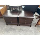 A PAIR OF STAG MINSTREL BEDSIDE CHAIRS ENCLOSING TWO DRAWERS AND A SLIDE