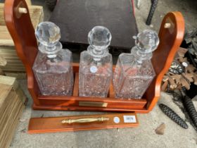 AN MDF TANTALUS AND THREE CUT GLASS DECANTERS