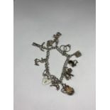 A SILVER CHARM BRACELET WITH TEN CHARMS AND A HEART PADLOCK
