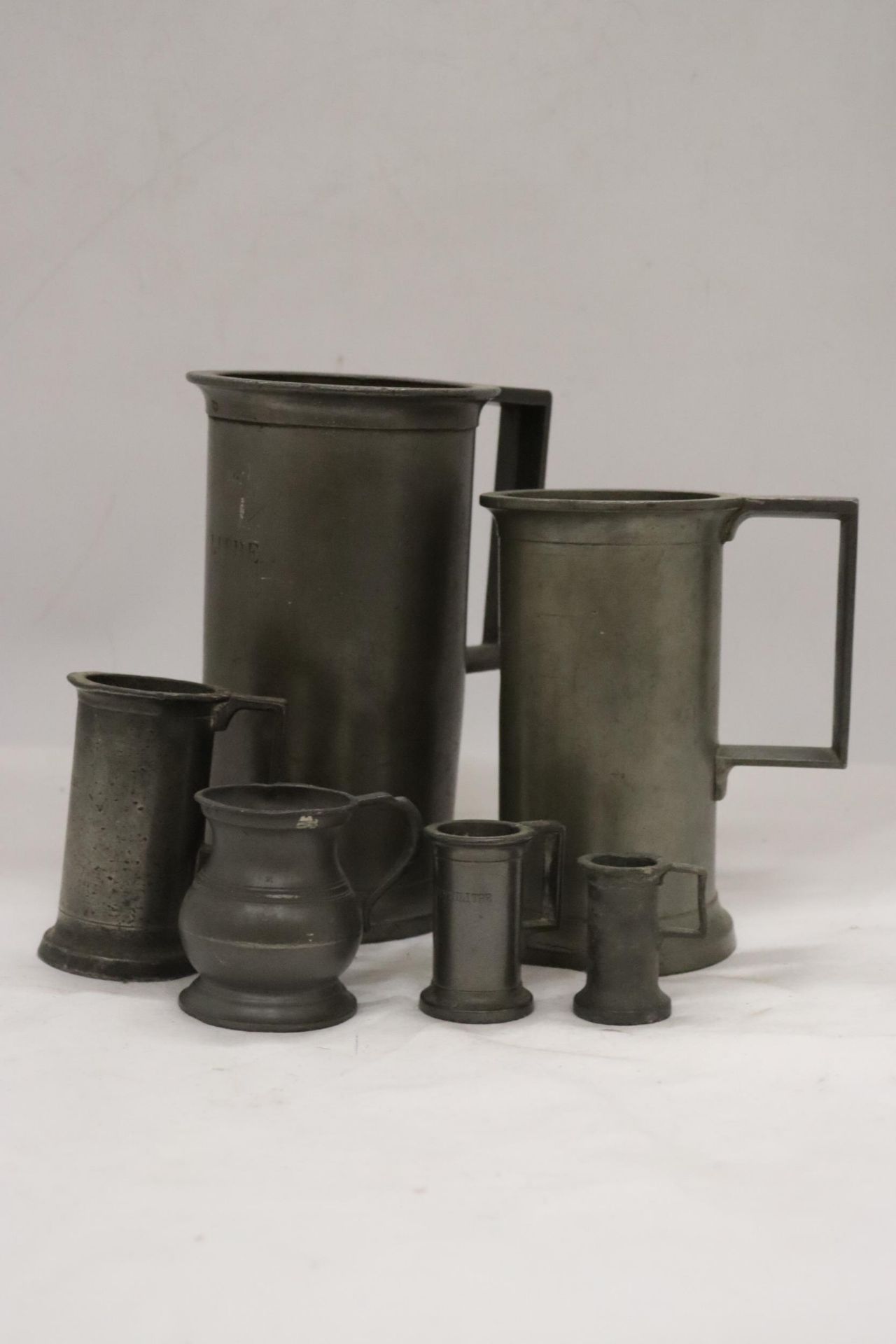 A COLLECTION OF ANTIQUE FRENCH PEWTER TANKARDS OF VARYING SIZES - 6 IN TOTAL