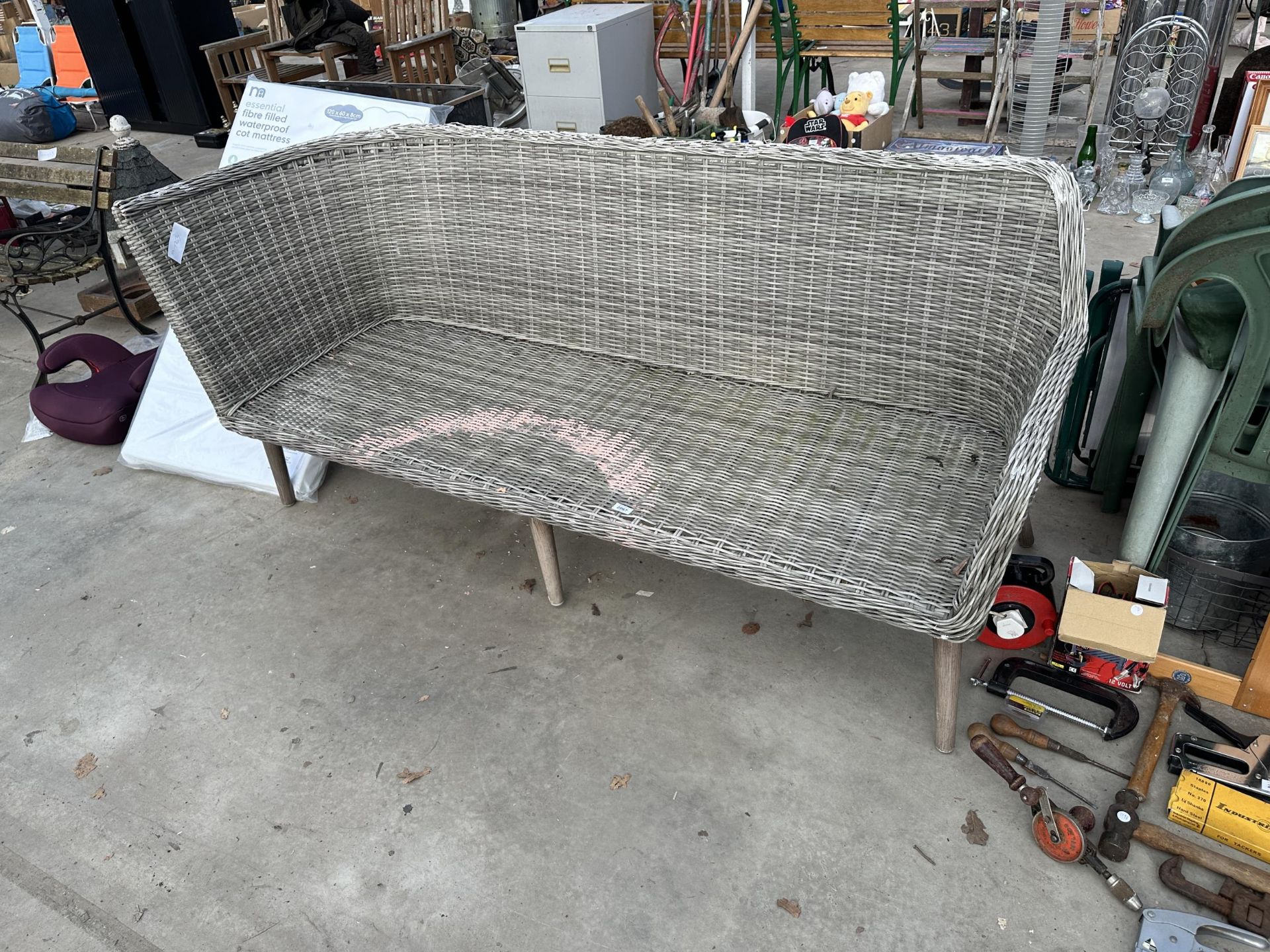 A LARGE WICKER THREE SEATER BENCH