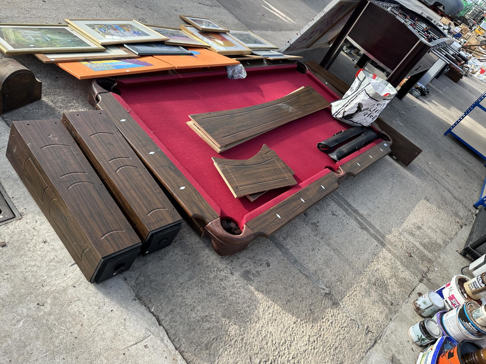 A LARGE POOL TABLE WITH TWO CUES AND A SET OF BALLS