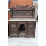 A HEAVILY CARVED GOTHIC OAK SIDEBOARD WITH DEER HUNTING SCENE AND MYTHICAL FIGURE, RAISED BACK,