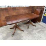 A MAHOGANY TWIN PEDESTAL DINING TABLE WITH THREE EXTRA LEAVES