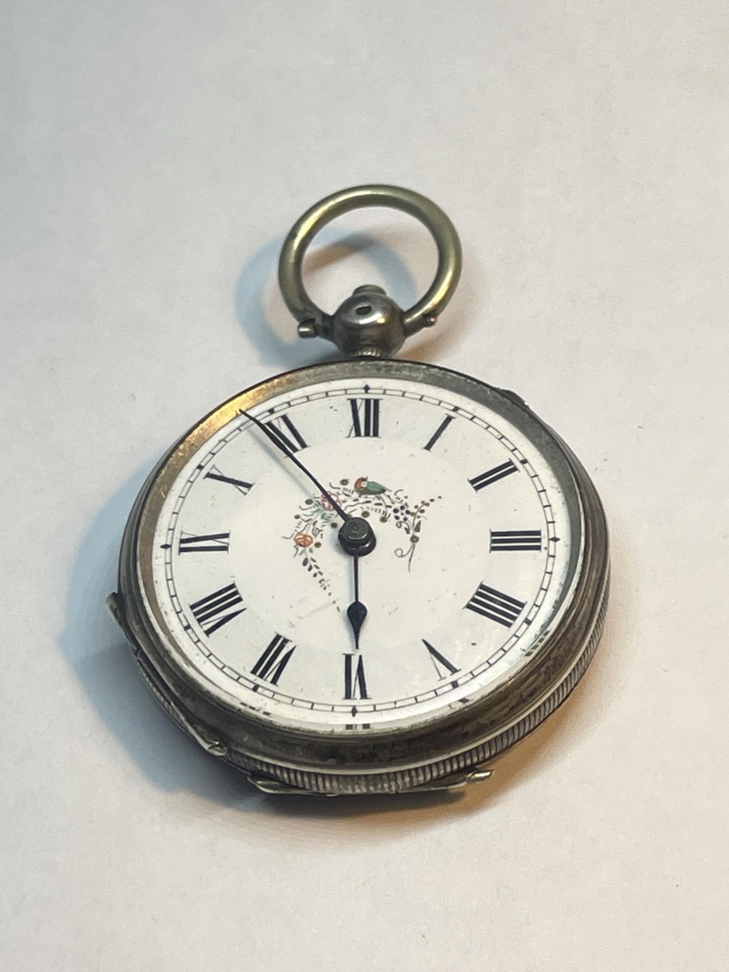 A MARKED 800 SILVER POCKET WATCH WITH WHITE ENAMEL DECORATIVE FACE AND ROMAN NUMERALS