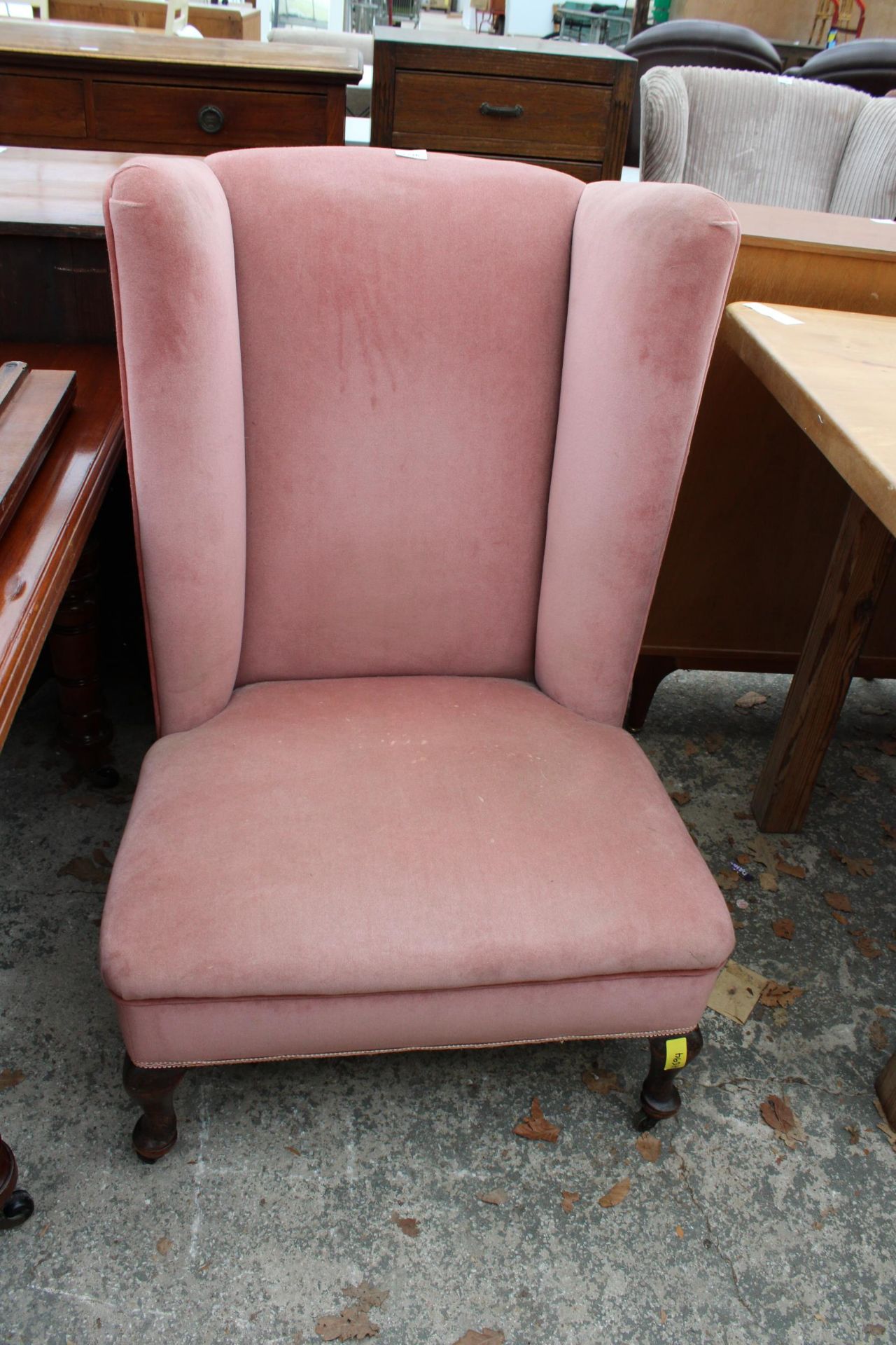 AN EARLY 20TH CENTURY LOW WINGED NURSING CHAIR ON FRONT CABRIOLE LEGS