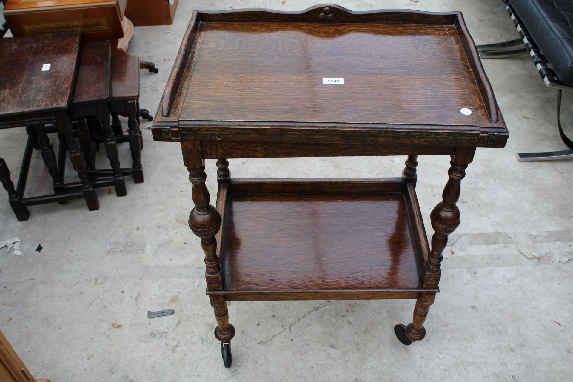 AN EARLY 20TH CENTURY OAK FOLD OVER GAMES TABLE/TROLLEY ON TURNED LEGS 24" WIDE