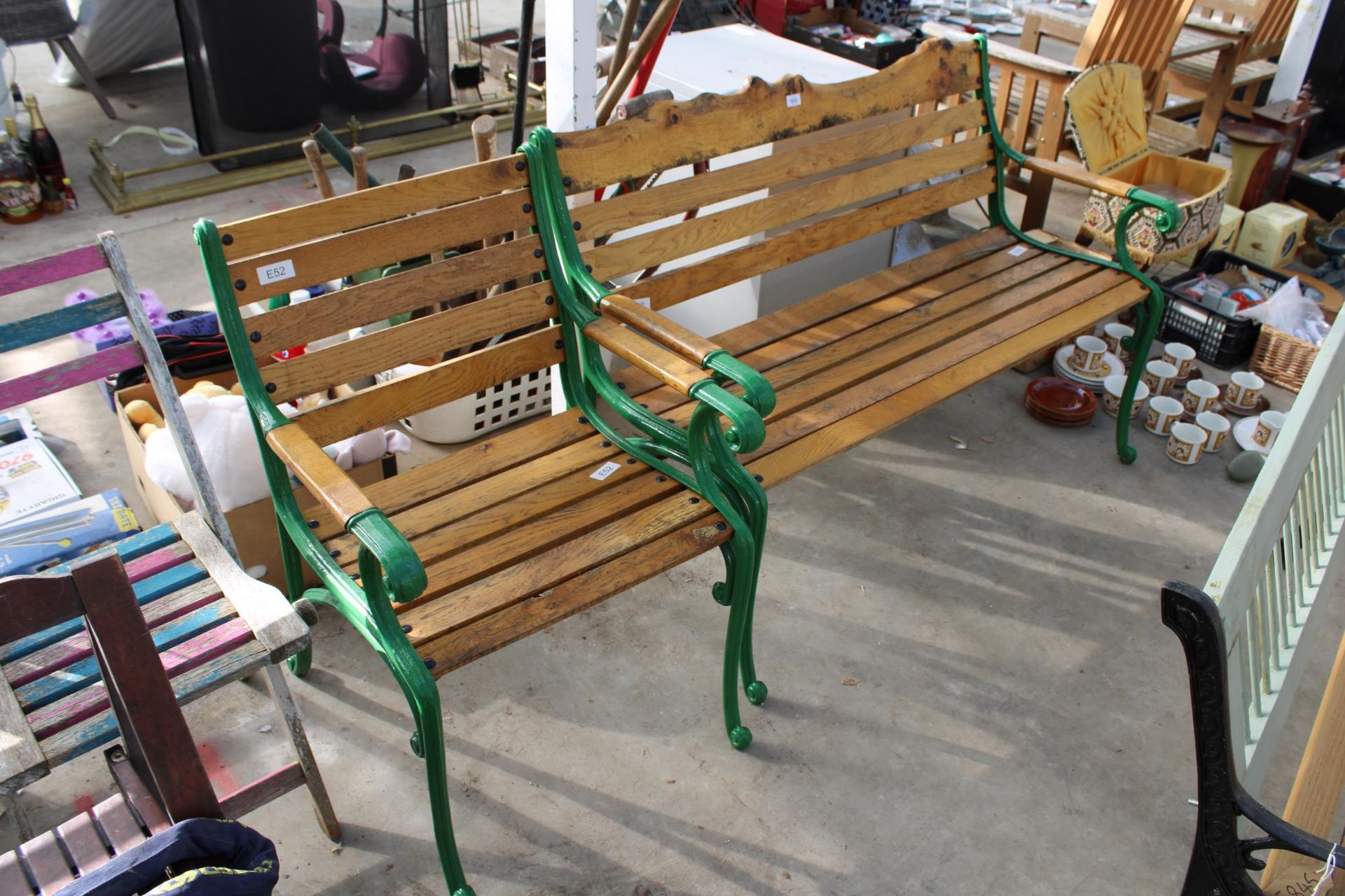 A WOODEN SLATTED GARDEN BENCH AND CHAIR BOTH WITH CAST ENDS