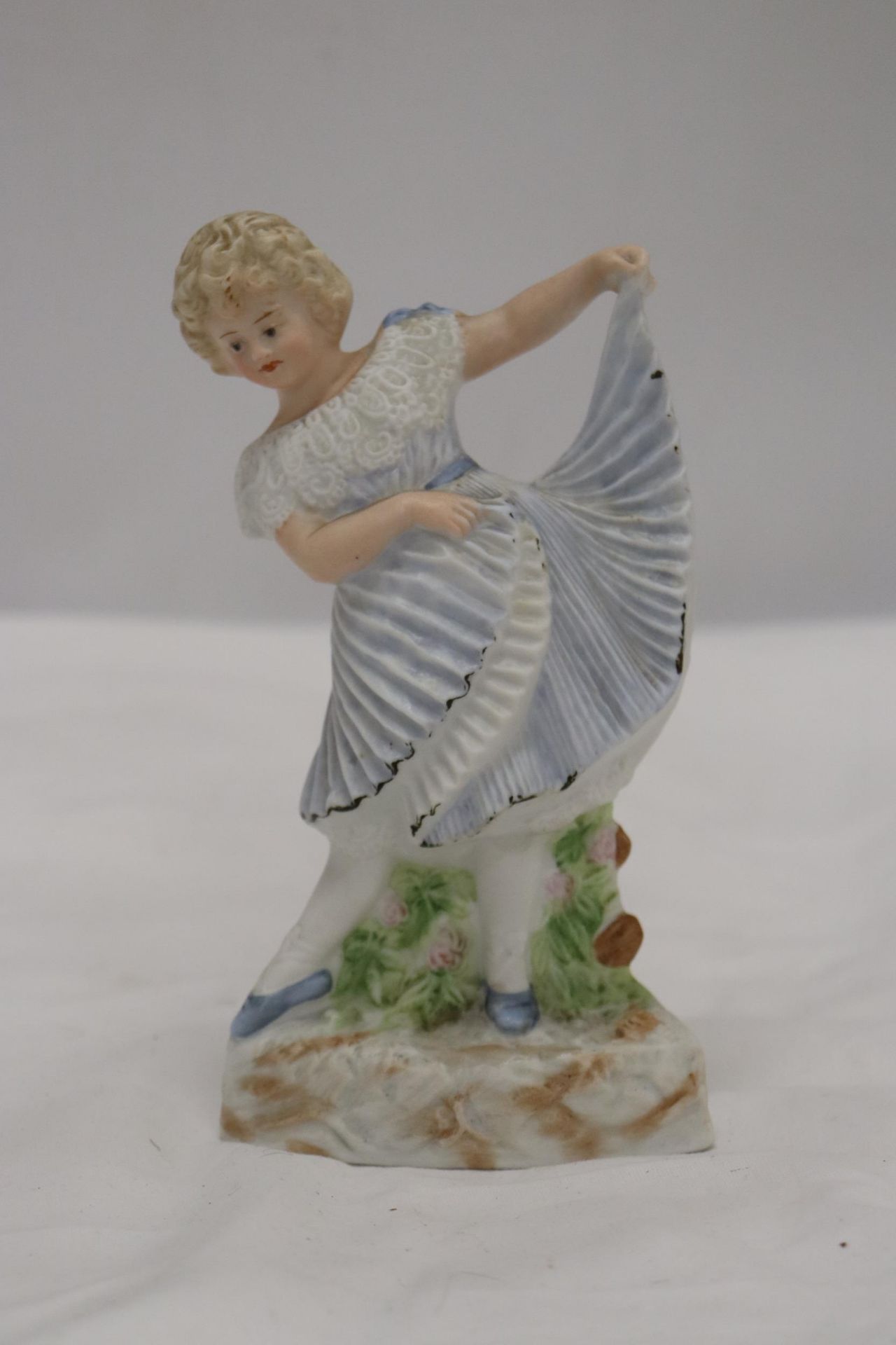 A BISQUE FIGURE OF A YOUNG LADY, MARKED TO THE BASE