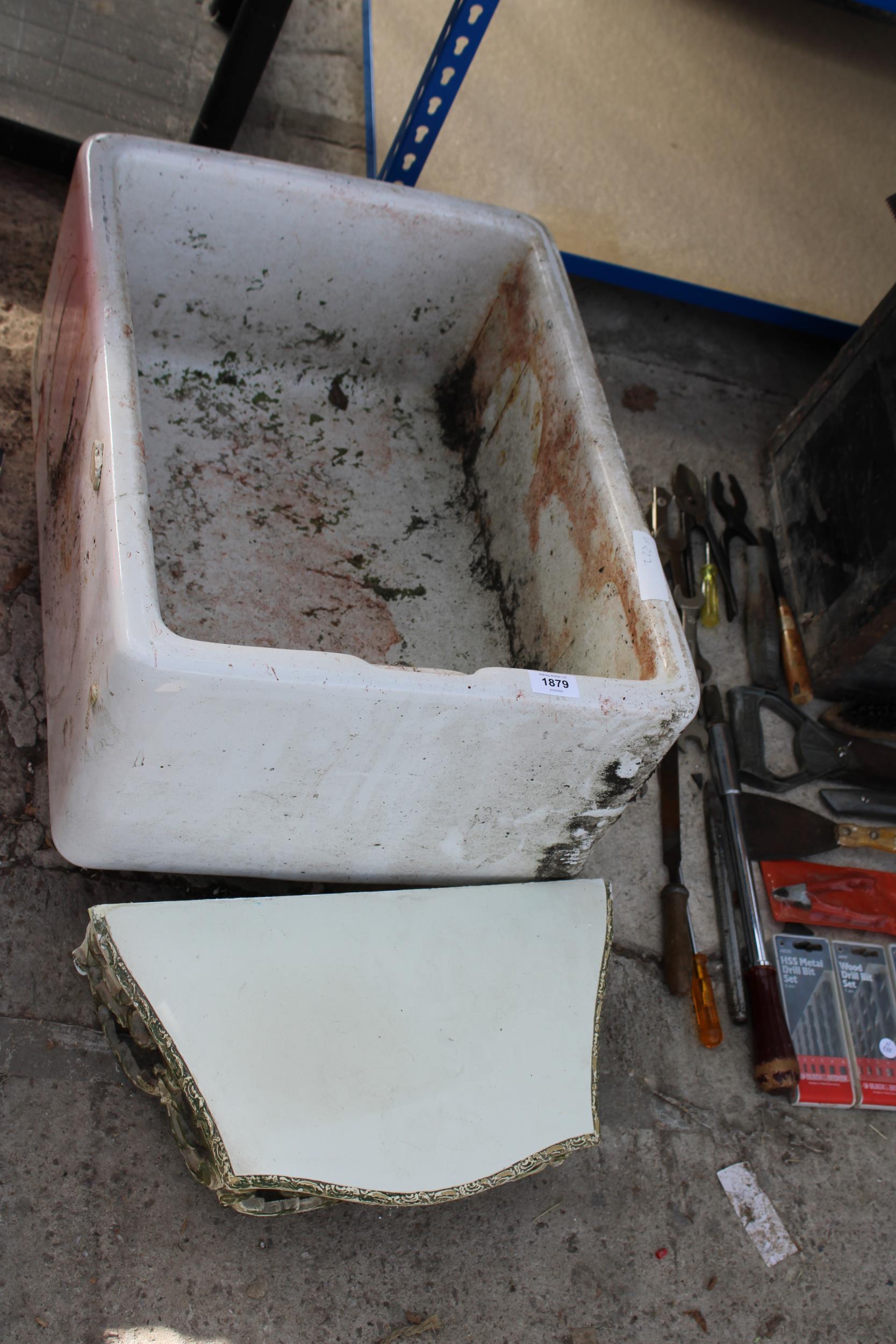 A WHITE BELFAST SINK AND A DECORATIVE WOODEN WALL SHELF