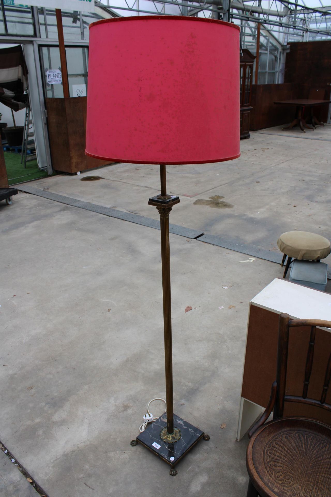 A BRASS CORINTHIAN STYLE STANDARD LAMP WITH SHADE