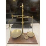 A SET OF BRASS BALANCE SCALES ON A WOODEN BASE WITH WEIGHTS W & T AVERY