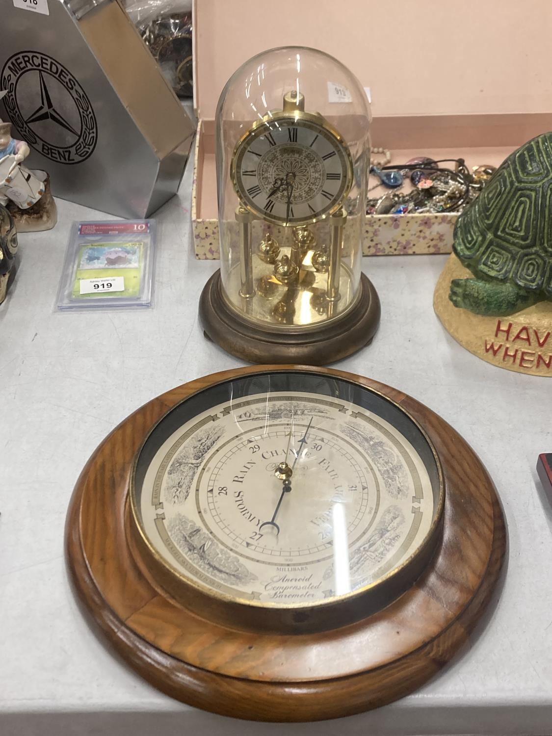 A VINTAGE DOMED GERMAN QUARTZ ANNIVERSARY CLOCK TOGETHER WITH AN ANEROID COMPENSATED BAROMETER BY