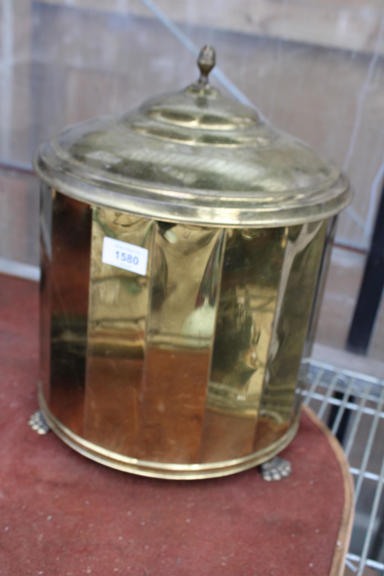 A VINTAGE BRASS LIDDED COAL BUCKET WITH LION PAW FEET