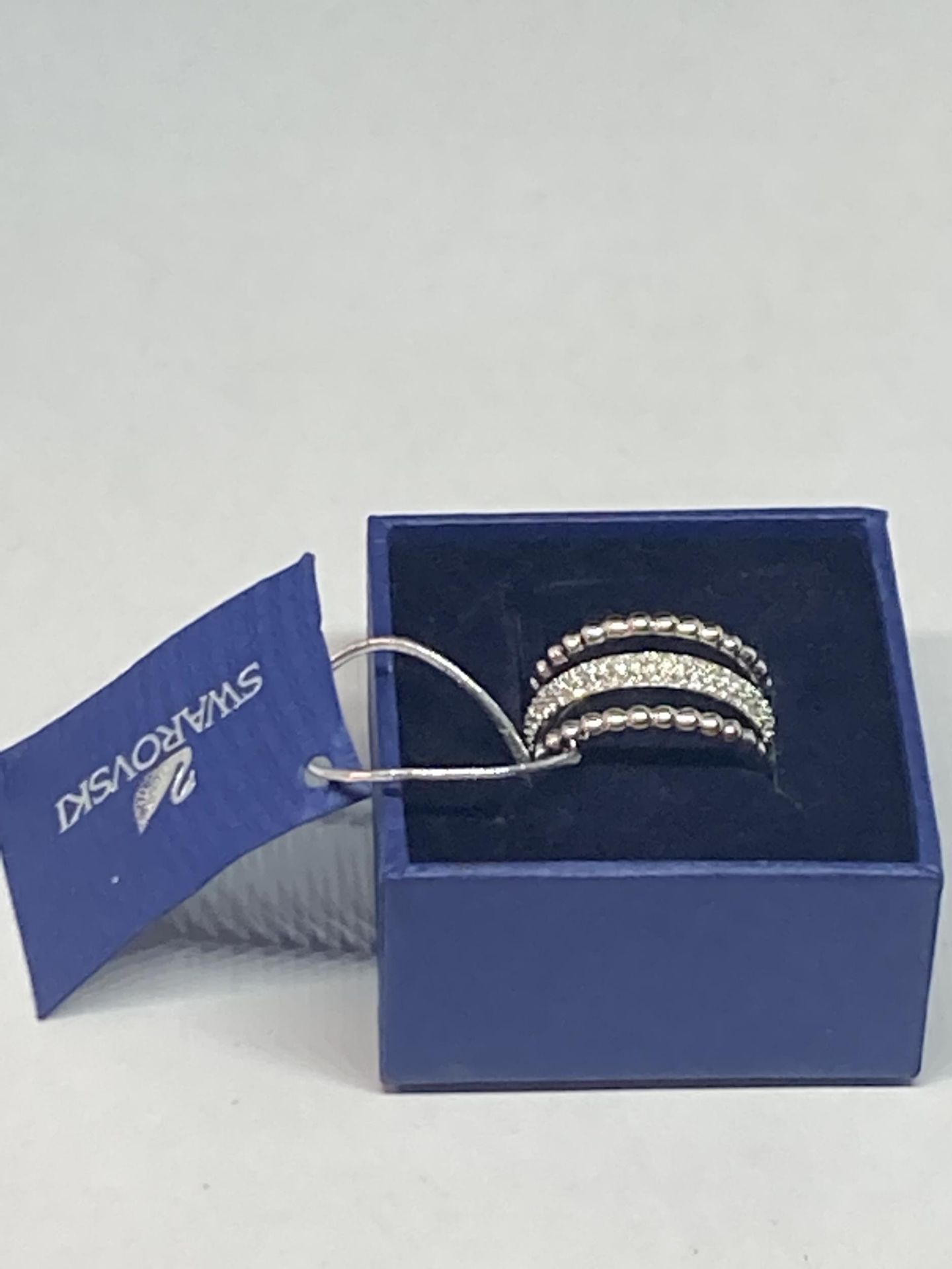 A SWAROVSKI CRYSTAL RING SIZE Q/R WITH LABEL AND PRESENTATION BOX