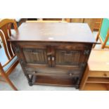 AN OAK JACOBEAN STYLE TWO DOOR LINEN FOLD CUPBOARD WITH SINGLE DRAWER ON AN OPEN BASE WITH TURNED