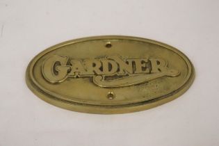 AN OVAL BRASS GARDNER SIGN