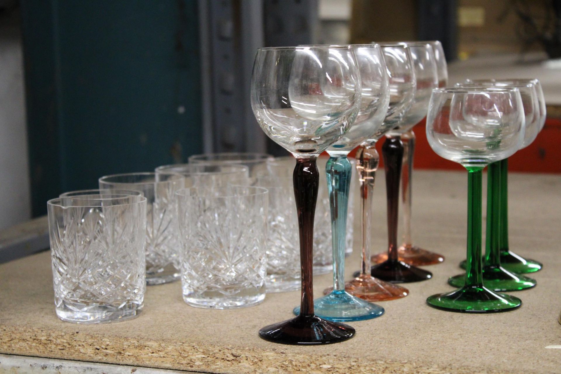 A QUANTITY OF WINE GLASSES WITH COLOURED STEMS AND CUT GLASS TUMBLERS