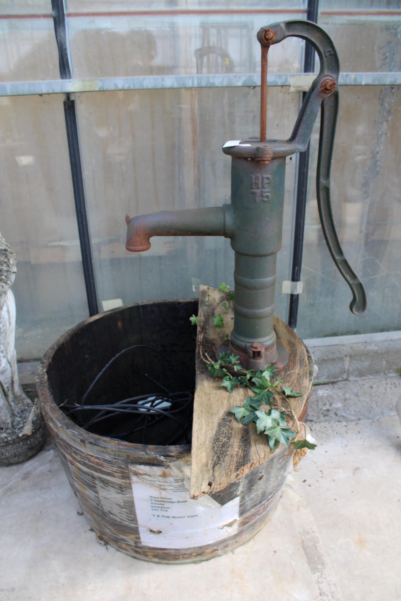 A VINTAGE WOODEN BARREL WATER FEATURE WITH VINTAGE CAST IRON WATER PUMP AND ELECTRIC PUMP