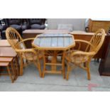 A BAMBOO AND WICKER TABLE WITH GLASS TOP AND A PAIR OF ELBOW CHAIRS