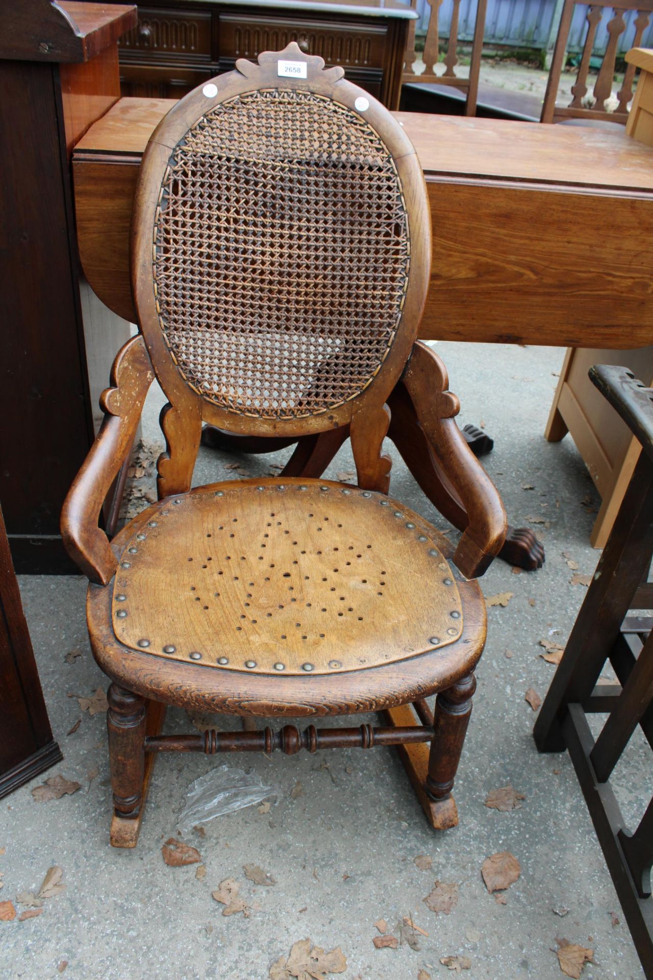 A VICTORIAN SATINWOOD ROCKING CHAIR WITH SPLIT CANE BACK