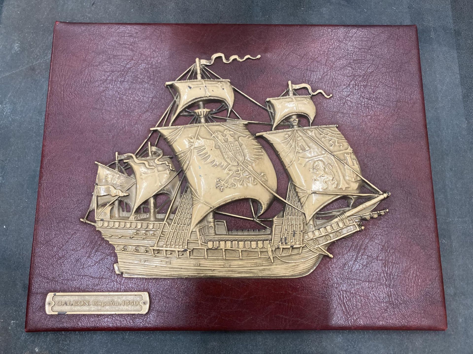 A VINTAGE EMBOSSED SPANISH GALLEON ON RED MOROCCO LEATHER, 30CM X 24CM