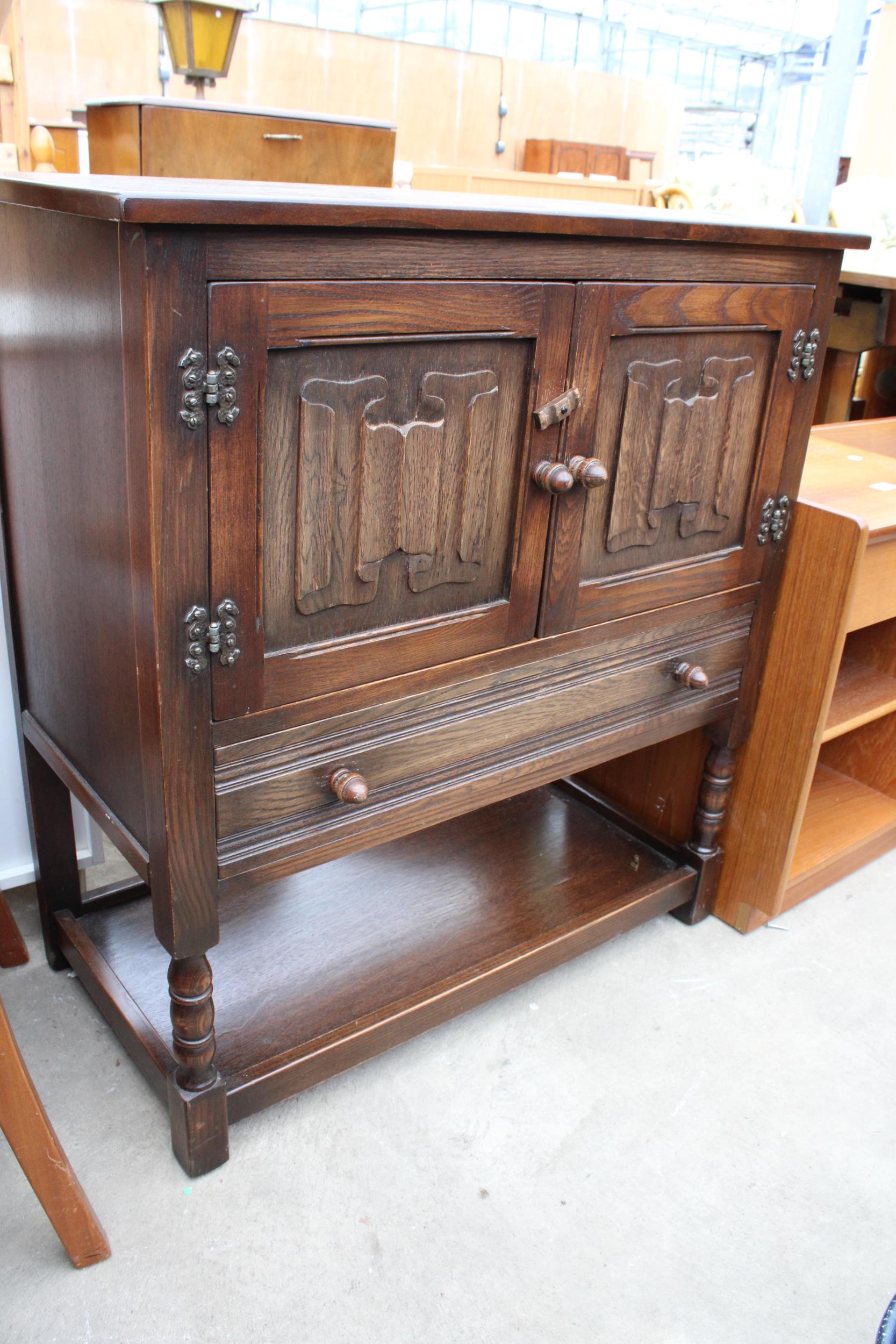AN OAK JACOBEAN STYLE TWO DOOR LINEN FOLD CUPBOARD WITH SINGLE DRAWER ON AN OPEN BASE WITH TURNED - Image 2 of 2
