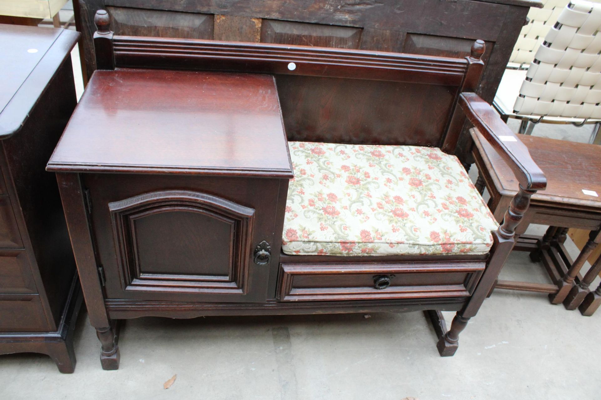 AN OAK TELEPHONE TABLE WITH SINGLE CUPBOARD AND DRAWER