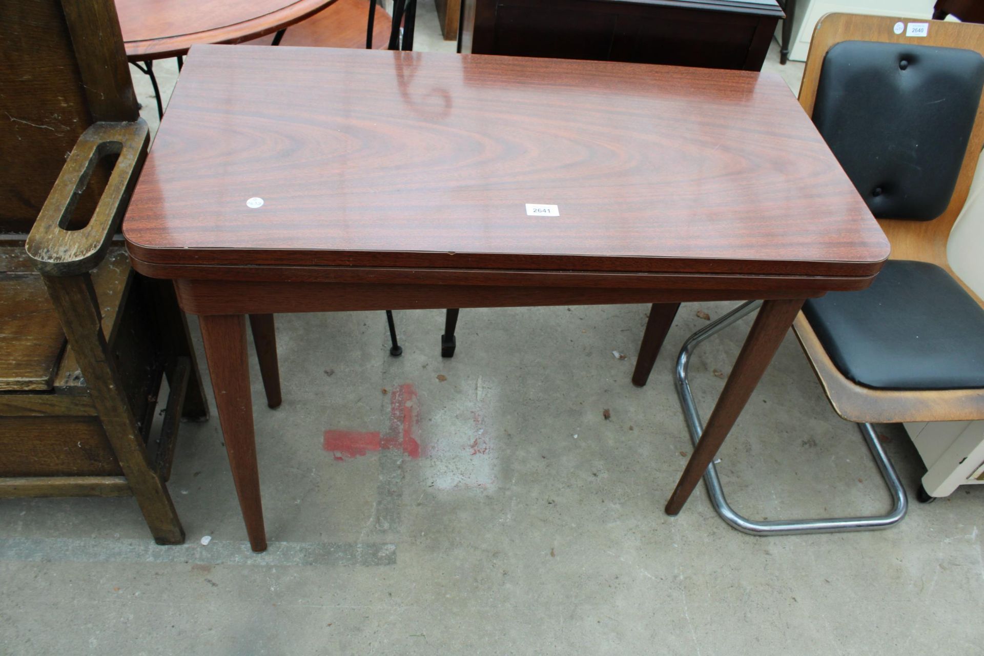 A MODERN FORMICA FOLD OVER TABLE ON METAL LEGS