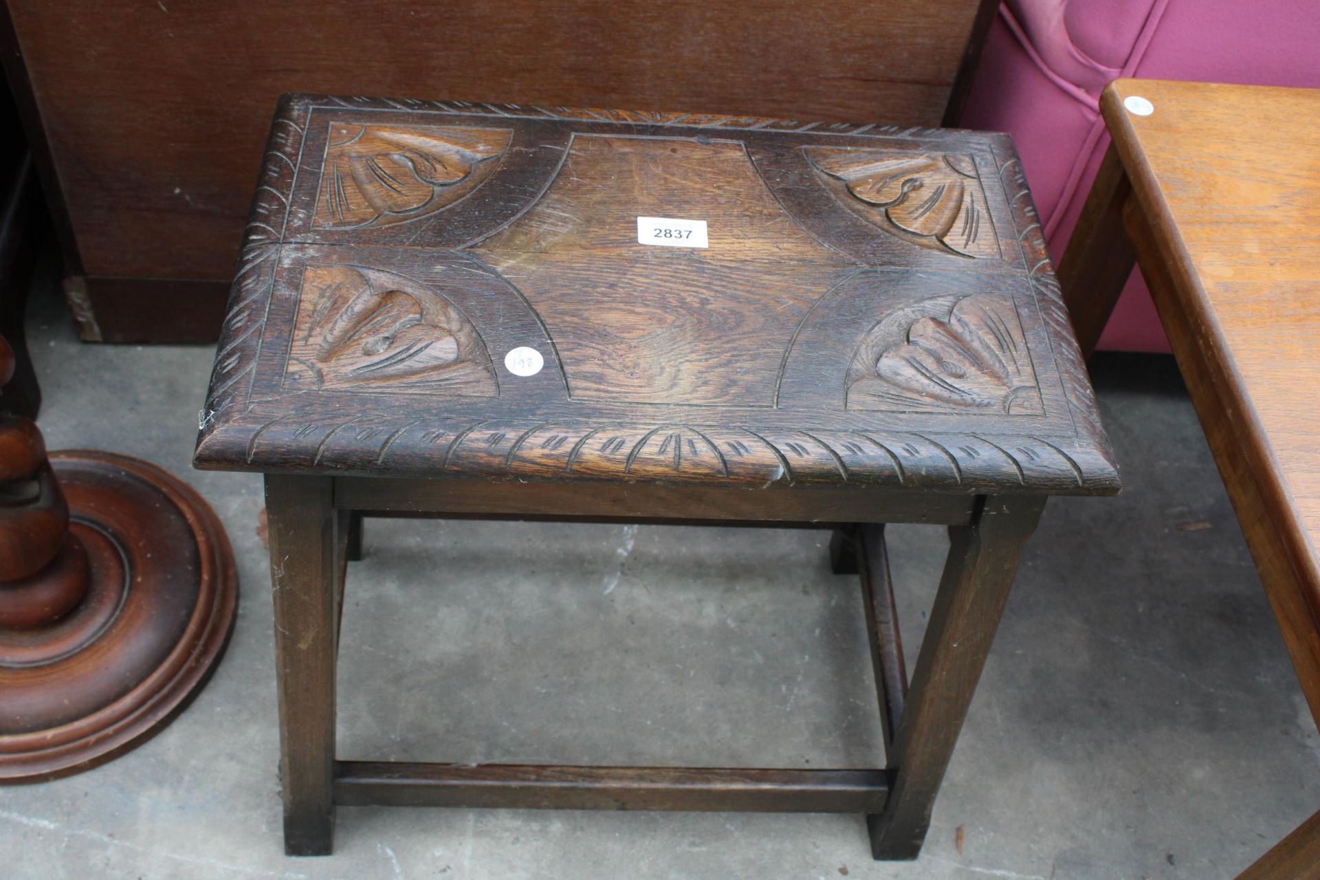 AN OAK JACOBEAN STYLE STOOL WITH CARVED TOP