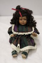 A VINTAGE CHINA DOLL IN SEATED POSE