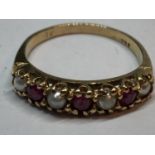 A 9 CARAT GOLD RING WITH FOUR SEED PEARLS AND THREE RED STONES IN A LINE GROSS WEIGHT 2.18 GRAMS
