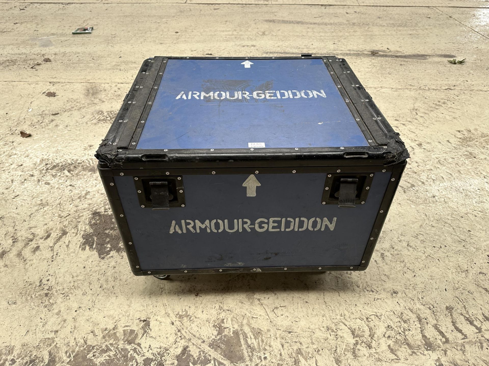 AN "ARMOURGEDDON" TRANSPORT BOX ON FOUR TROLLEY WHEELS