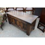 AN OAK OLD CHARM BLANKET CHEST WITH CARVED PANEL FRONT 45" WIDE