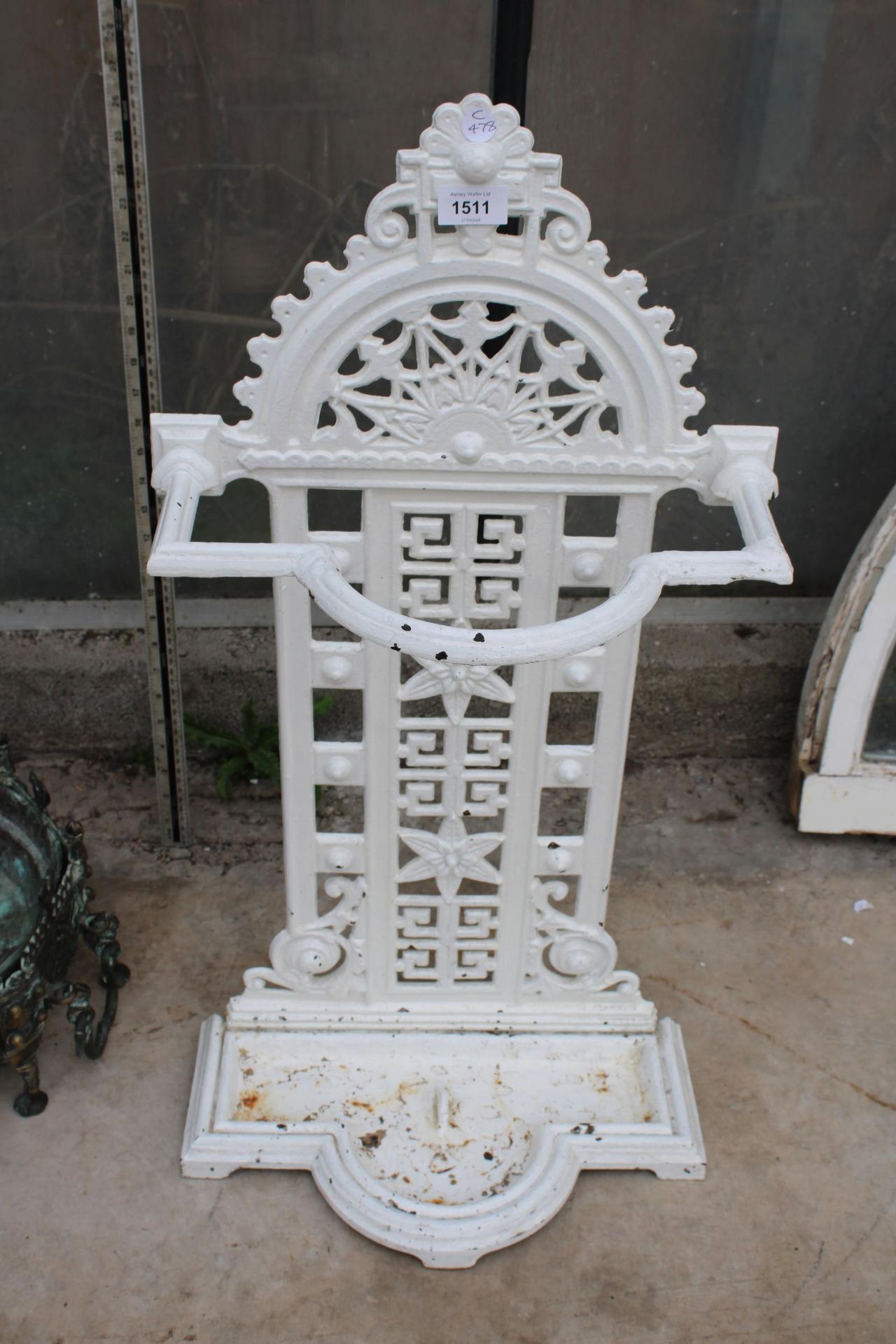 AN ANTIQUE CAST IRON STICK STAND WITH DRIP TRAY