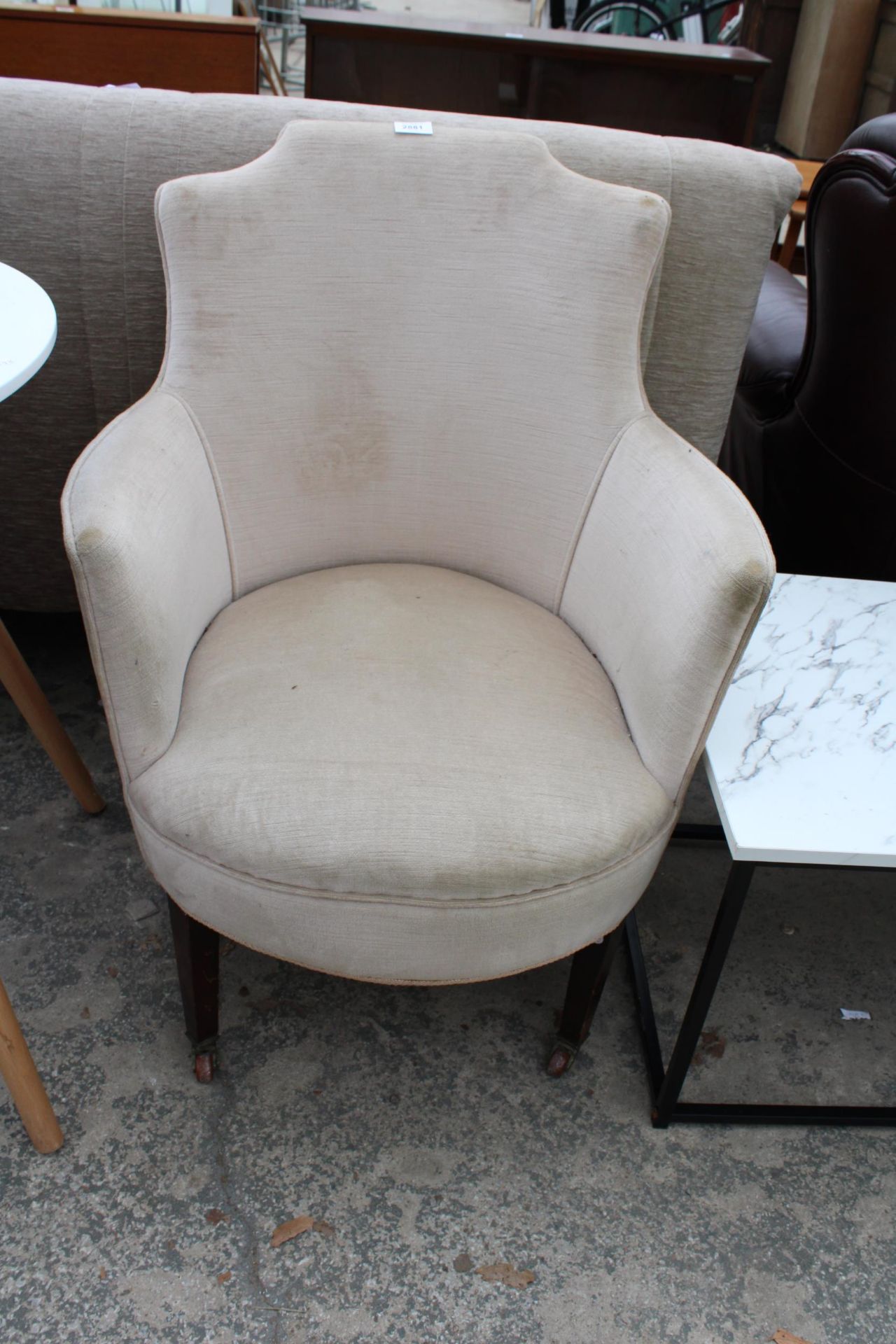 AN EDWARDIAN TUB CHAIR ON TAPERED FRONT LEGS