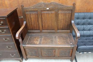 AN OAK JACOBEAN STYLE SETTLE WITH LINENFOLD BACK, CARVED PANEL FRONT AND LIFT-UP SEAT, 42" WIDE