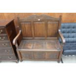 AN OAK JACOBEAN STYLE SETTLE WITH LINENFOLD BACK, CARVED PANEL FRONT AND LIFT-UP SEAT, 42" WIDE