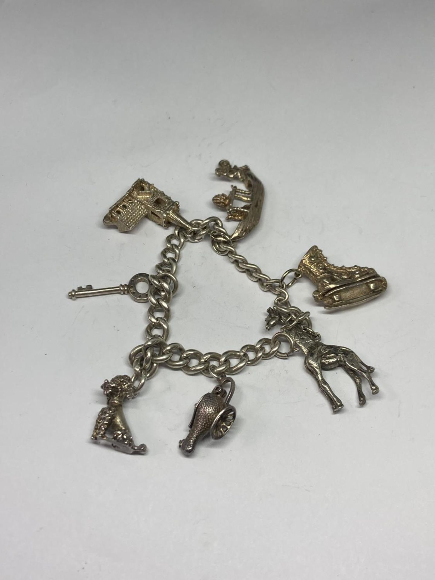 A SILVER CHARM BRACELET WITH SEVEN LARGE CHARMS