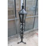 A DECORATIVE METAL LAMP POST WITH TRIPOD BASE