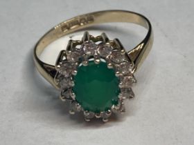 A 9 CARAT GOLD RING WITH CENTRE GREEN STONE SURROUNDED BY CUBIC ZIRCONIAS SIZE K