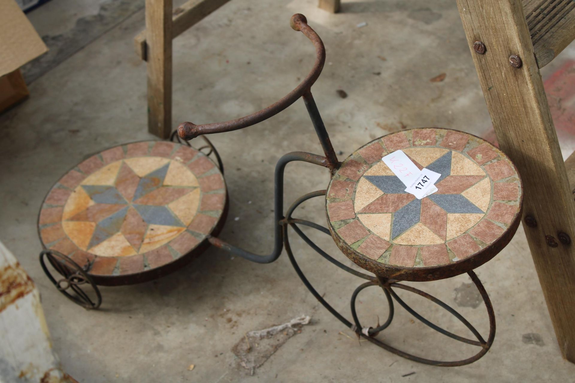 A DECORATIVE TILED PLANT STAND IN THE FORM OF A BIKE