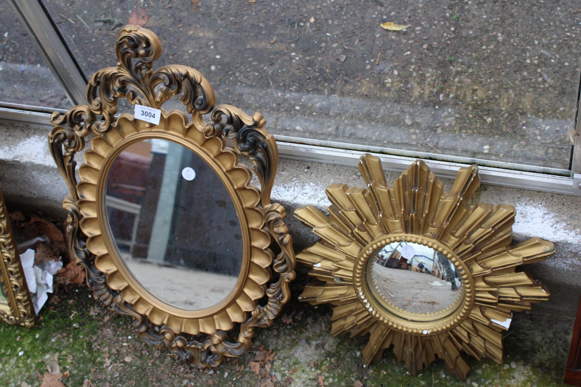 A GILT EFFECT STARBURST MIRROR AND OVAL MIRROR
