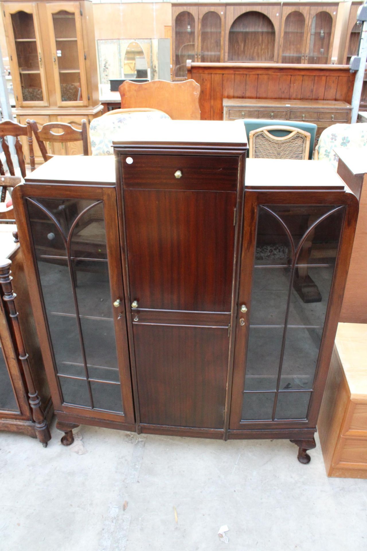 A MID 20TH CENTURY MAHOGANY TWO DOOR GLAZED DISPLAY CABINET WITH CENTRE CUPBOARD AND DRAWER ON