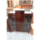 A MID 20TH CENTURY MAHOGANY TWO DOOR GLAZED DISPLAY CABINET WITH CENTRE CUPBOARD AND DRAWER ON