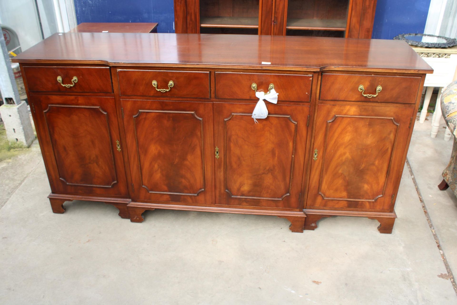 A MAHOGANY AND CROSS BANDED BREAKFRONT REPRODUX SIDEBOARD ENCLOSING FOUR DRAWERS AND FOUR CUPBOARDS,