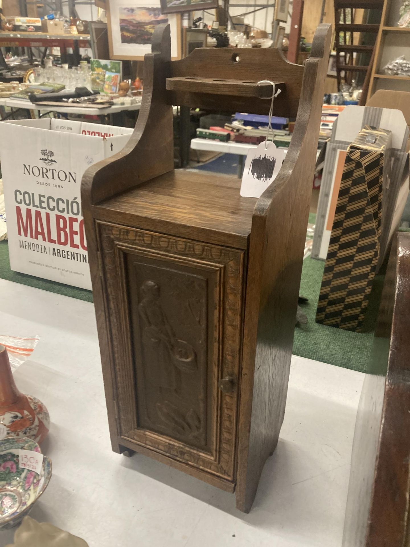 A VINTAGE OAK SMOKERS CABINET WITH CARVED DOOR